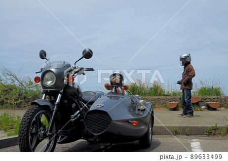 海岸近くの駐車場で熊の縫いぐるみを載せてくつろぐドライバー 89633499