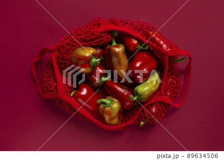 Fresh bell peppers in eco friendly bag on the red background. 89634506
