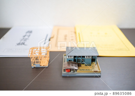 (不動産イメージ）住宅と建設物件の模型と権利書 89635086
