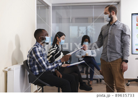 HR department manager receiving unemployed man CV resume in marketing company waiting room. African american person giving businessman job application while sitting in lobby area. 89635733