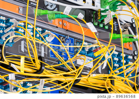 fiber optic cables plugged in network switch panels inside data center 89636568