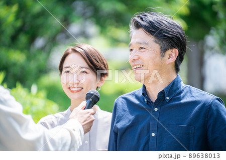 インタビューを受けるミドル夫婦(カップル・屋外・新緑・取材) インタビューを受けるミドル夫婦(カップル・屋外・新緑・取材) 89638013