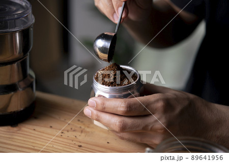 Barista holding moka pot with ground coffee in coffee shop. 89641956