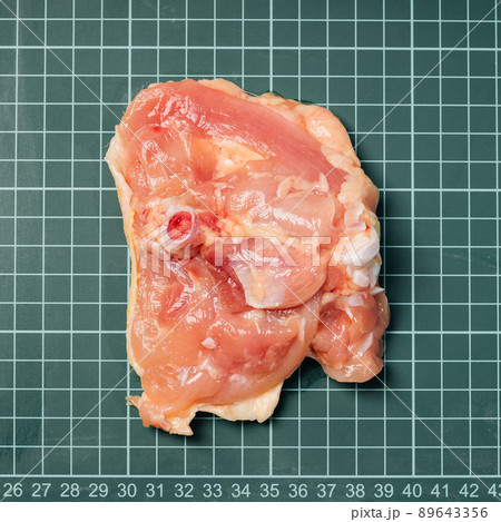 Raw chicken thigh with skin, boneless, for cooking on wooden cutting board.Chicken thigh meat on a linear board. 89643356