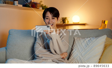 スマートフォンで動画を視聴する若い女性 89645633