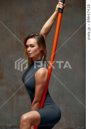 beautiful girl in sports uniform is training kung fu in the studio, fighter athlete, practicing martial arts with a stick 89647419