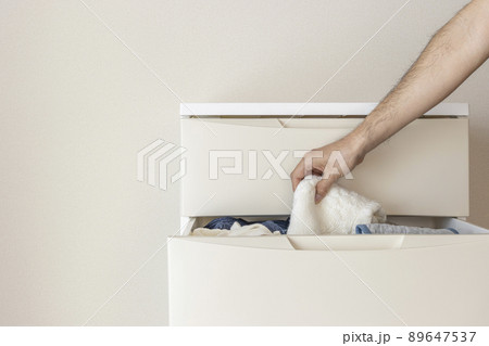 部屋に置いたチェストと、男の手（30代、顔無し） 89647537