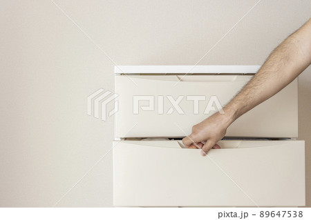 部屋に置いたチェストと、男の手（30代、顔無し） 89647538