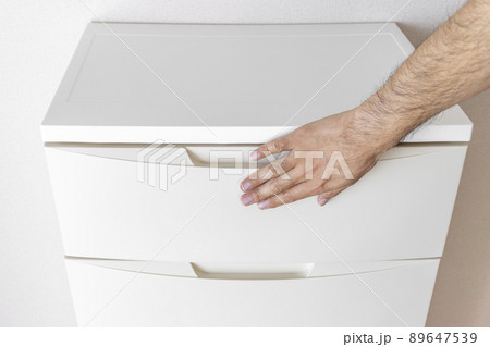 部屋に置いたチェストと、男の手（30代、顔無し） 89647539