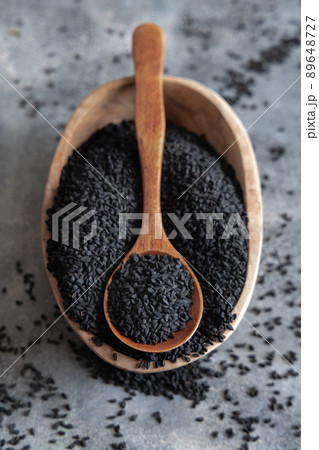 Indian spice Black cumin (nigella sativa or kalonji) seeds in bowl with spoon on wooden table top view. Indian spice Black cumin (nigella sativa or kalonji) seeds in bowl with spoon on wooden table top view. 89648727