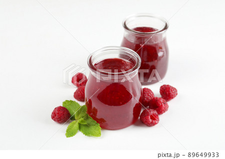 Jars of raspberry jam with ingredients on white background Jars of raspberry jam with ingredients on white background 89649933
