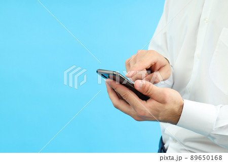 Businessman using phone on blue background, space for text Businessman using phone on blue background, space for text 89650168