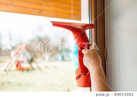 Cleaning windows with portable professional vacuum cleaner. 89652082