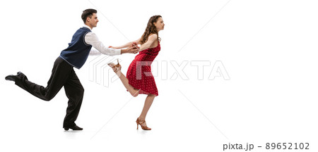 Quickstep. Beautiful girl and stylish man in vintage retro style outfits dancing isolated on white background. Timeless traditions, 60s,70s american fashion style and art Quickstep. Beautiful girl and stylish man in vintage retro style outfits dancing isolated on white background. Timeless traditions, 60s,70s american fashion style and art 89652102