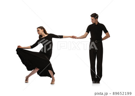 Dynamic portrait of young emotive dancers in black outfits dancing ballroom dance isolated on white background. Concept of art, beauty, music, style. 89652199