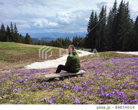 Man on wooden bench enjoying mountains landscape 89654014