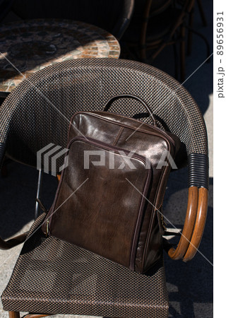 Brown leather backpack on the stylish chair Brown leather backpack on the stylish chair 89656931
