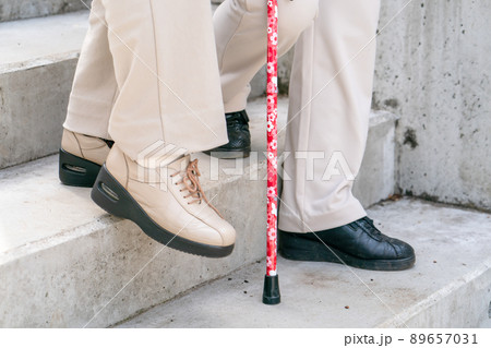 階段を降りるシニア女性　膝痛 89657031