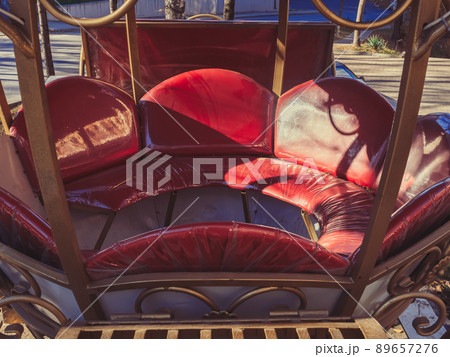 Red decorative leather carriage seat. Street photo zone. Decorative vintage element Red decorative leather carriage seat. Street photo zone. Decorative vintage element 89657276