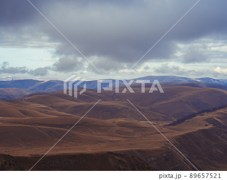 Brown autumn Caucasian mountains under fluffy clouds. View from the highlands. Countryside of Kislovodsk Brown autumn Caucasian mountains under fluffy clouds. View from the highlands. Countryside of Kislovodsk 89657521
