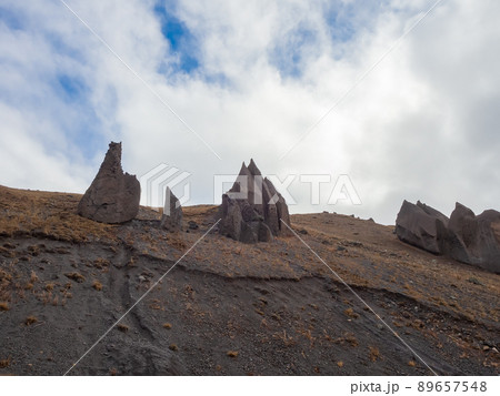 On the tops of the mountains under the cloudy sky are huge sharp stone battlements. Magmatic pyramids. The consequences of the ancient eruption of the Elbrus volcano 89657548