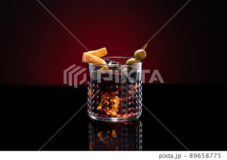 Vermouth cocktail with ice isolated on dark red background with copy space. Vermouth cocktail with ice isolated on dark red background with copy space. 89658775