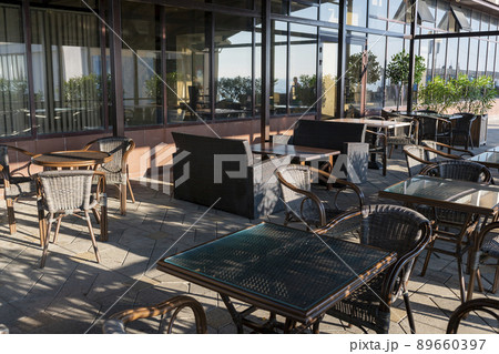 Summer cafe with wooden tables and wicker chairs. 89660397