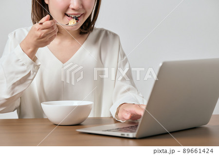 テレワークをしながらオートミールを食べる若いヴィーガン女性 89661424