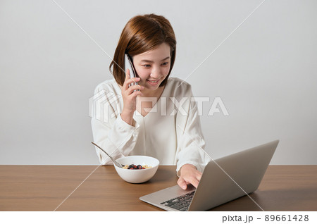 テレワークをしながらオートミールを食べる若いヴィーガン女性 テレワークをしながらオートミールを食べる若いヴィーガン女性 89661428