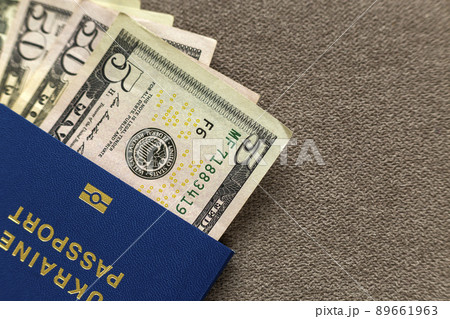 Ukrainian passport and money, American dollars banknotes bills on copy space background, top view. Traveling and finance problems concept. Ukrainian passport and money, American dollars banknotes bills on copy space background, top view. Traveling and finance problems concept. 89661963