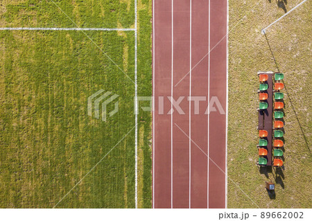 Top view of red running tracks and green grass lawn. Infrastructure for sports activities. 89662002