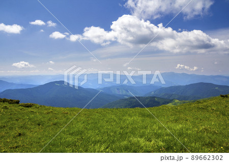 Green mountains panorama under blue sky on bright sunny day. Tourism and traveling concept, copy space background. 89662302