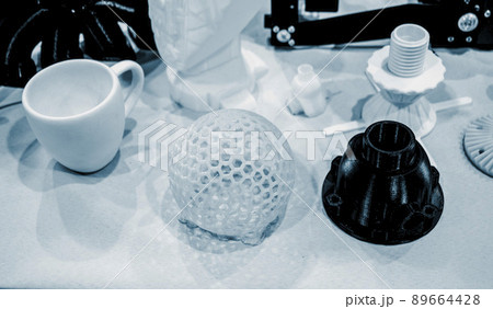 Models printed on 3D printer. Many objects printed on 3D printer made of plastic close-up. Prototypes of various shapes made by 3d printer. 3D printed models. Concept new modern printing technology 89664428