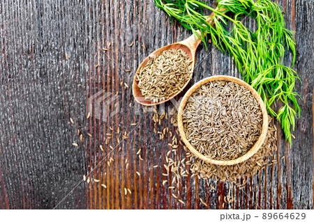 Cumin seeds in bowl and spoon with herbs on board top Cumin seeds in bowl and spoon with herbs on board top 89664629