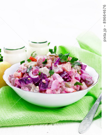 Salad with herring and beetroot in bowl on towel 89664676