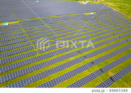 Aerial view of solar power plant on green field. Electric panels for producing clean ecologic energy. Aerial view of solar power plant on green field. Electric panels for producing clean ecologic energy. 89665389