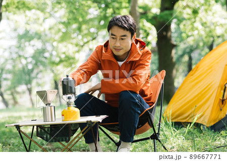 キャンプでコーヒーを淹れる男性 89667771