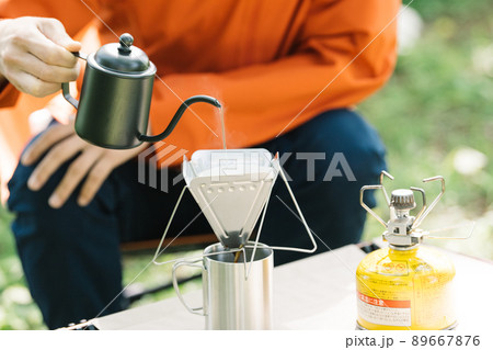 キャンプでコーヒーを淹れる男性 89667876