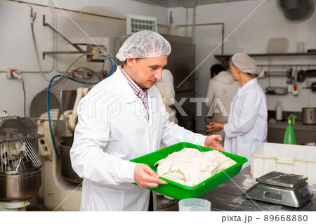 Baker preparing dough for rolling Baker preparing dough for rolling 89668880
