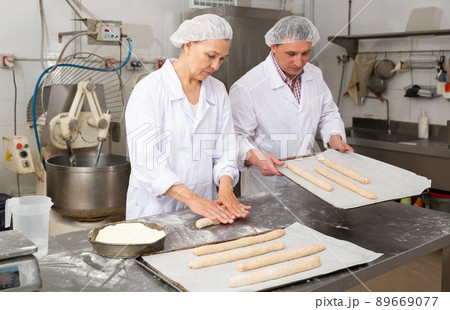 Bakery worker preparing raw baguette dough for baking 89669077