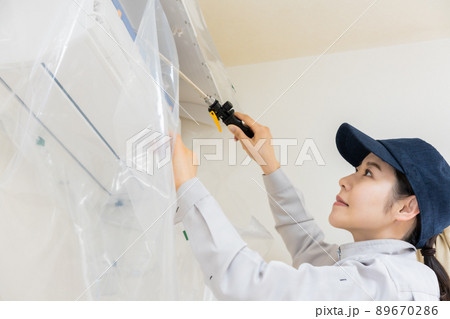 エアコン清掃をする女性スタッフ 89670286