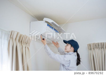 エアコン清掃をする女性スタッフ エアコン清掃をする女性スタッフ 89670292