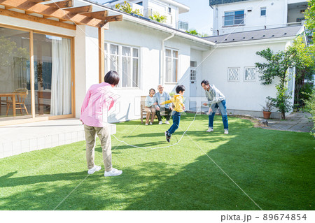 庭で遊ぶ三世代家族 89674854