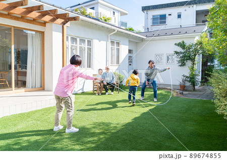 庭で遊ぶ三世代家族 89674855