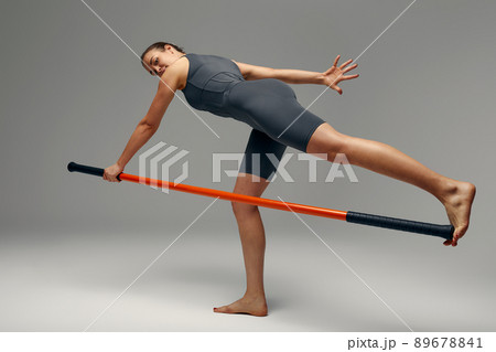 beautiful girl in sports uniform is training kung fu in the studio, fighter athlete, practicing martial arts with a stick 89678841
