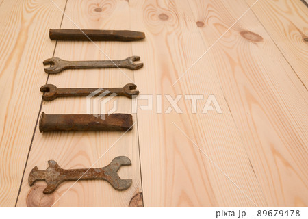 Rusty old open end wrenches, chiselson a wooden background Rusty old open end wrenches, chiselson a wooden background 89679478