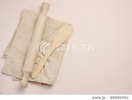 Wooden rolling pin for rolling dough on a beige background, top view. Copy space 89680462