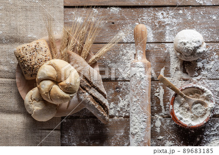 Bread with wheat ears and flour on wood board, top view. 89683185