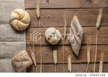 Bread with wheat ears and flour on wood board, top view. 89683188