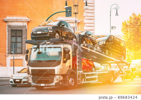 Auto-transport Carrying New Fiat Cars In European City Street. Auto Transport Broker Or Car Transporter 89683424